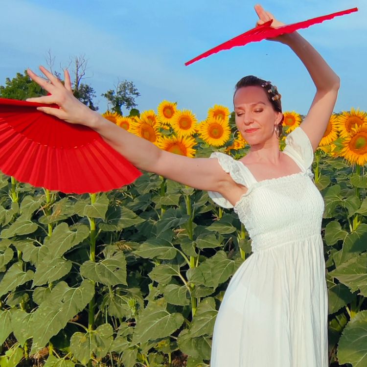 Kadri Merimaa dancing with red fans among sunflowers