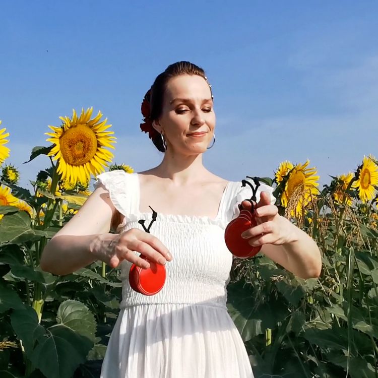 Kadri Merimaa playing castanets in a sunflower field